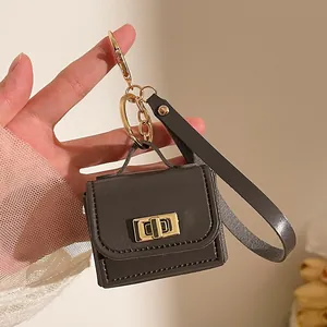 Mini portamonete portachiavi in ecopelle con dettagli dorati tenuto in mano