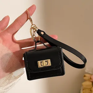 Vista dettagliata del mini portachiavi a borsa in pelle nera con finiture in metallo oro