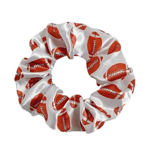 White satin scrunchie with orange American football print for sports hairstyles