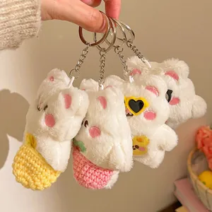 Lot de quatre porte-clés lapin en peluche blanche avec accessoires tricotés colorés