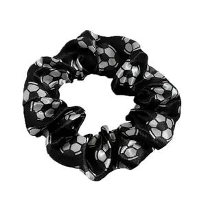 Detailed view of black satin scrunchie featuring silver football soccer ball pattern prints