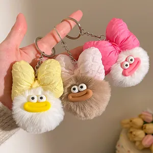 Gros plan d'un porte-clés peluche monstre avec grand nœud et traits de dessin animé