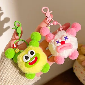 Close-up of cute monster plush keychains with furry texture and colorful letter beads