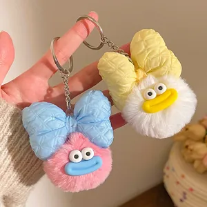 Détail d'un porte-clés en peluche avec nœud à carreaux et anneau en métal