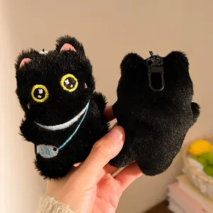 Close-up of cute black plush cat keychain with yellow eyes and blue fish bag accessory