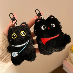 Close-up of two cute black plush cat keychains with fluffy texture and metal hooks