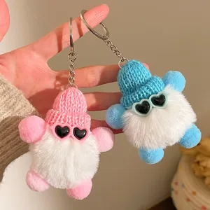 Détail de porte-clés en peluche avec lunettes cœur et bonnets en tricot rose et bleu