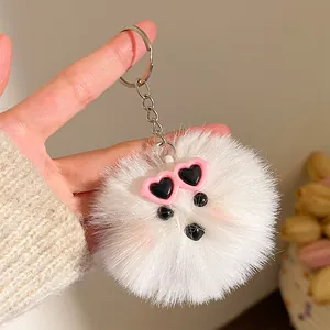Detail van witte pluche honden-sleutelhanger met roze hartvormige zonnebril en ring