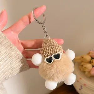 Détail d'un porte-clés en peluche créatif avec bonnet tricoté et lunettes de soleil cœur