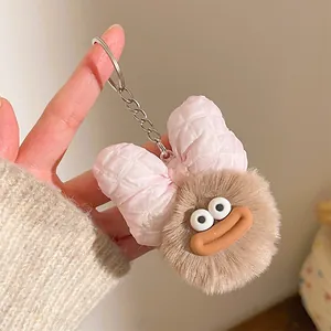 Détail d'un porte-clés en peluche avec lèvres épaisses et nœud à carreaux rose