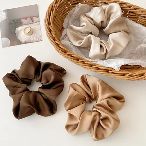 Lot de trois chouchous en satin aux tons terreux incluant marron et caramel