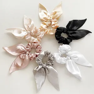 Detailed view of six-piece satin scrunchies with bunny ears in various elegant colors