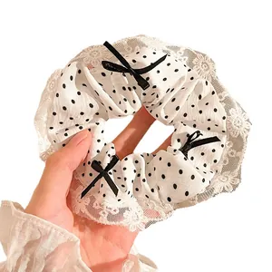 Coletero de lunares con borde de encaje blanco y un lazo negro pequeño decorativo