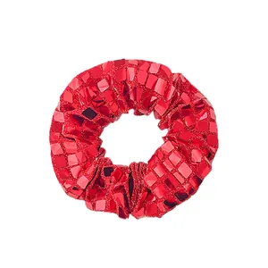 Détail d'un chouchou à paillettes rouge vif avec un fini métallique carré réfléchissant