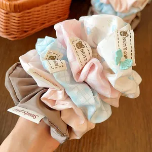 Detail showing various striped and plaid fabric scrunchies with sweet brand labels