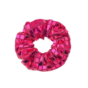 Détail montrant les paillettes carrées brillantes et la texture du chouchou rose fuchsia