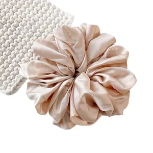 Oversized champagne satin silk scrunchie with soft pleats and elegant pearl luster