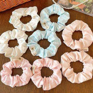 Floral and checkered scrunchies set in blue and pink on a wooden desk background