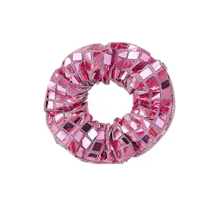 Détail macro du chouchou rose fuchsia orné de paillettes miroir carrées et brillantes