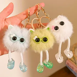 Détail de trois porte-clés monstres en peluche à longues jambes avec fourrure et crochet doré