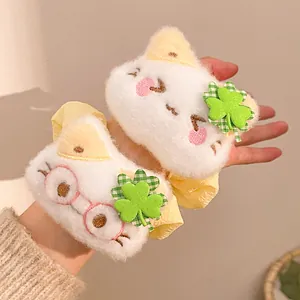 Detail of plush cat hair ties with green clover and cute cat face embroidery
