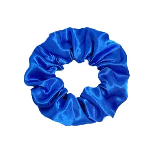 Close-up of a royal blue satin scrunchie with a silky texture and ruffled finish