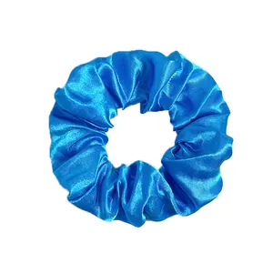 Close-up of a bright blue satin scrunchie with silky texture and smooth pleated design