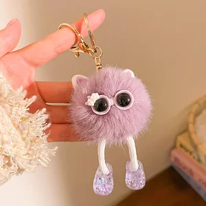Détail d'un porte-clés monstre en peluche violette avec lunettes et jambes tressées