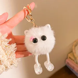 Détail d'un porte-clés monstre en peluche blanche avec de longues jambes et de grands yeux