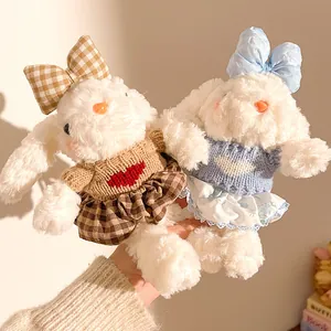 Gros plan de pendentifs lapins en peluche avec tenues tricotées marron et bleues douces