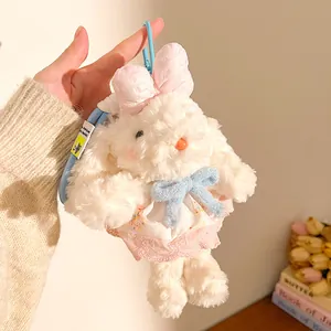 Détail de porte-clés lapin en peluche blanche avec robe en dentelle rose et nœuds