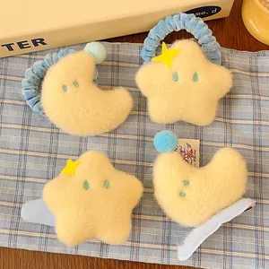 Détail de barrettes en peluche jaune en forme d'étoile et de lune avec broderies