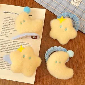 Détail de barrettes et chouchous en peluche jaune avec motifs étoiles et lune mignons
