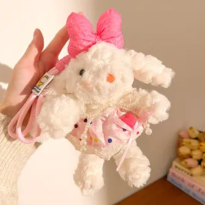 Détail d'un lapin en peluche blanc avec nœud rose et robe à carreaux sur un cordon