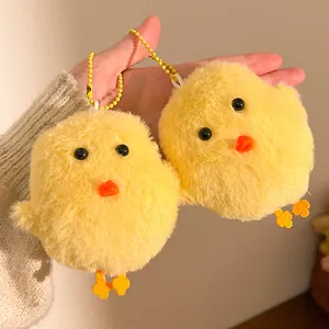 Close-up of two soft yellow plush chick keychains with beaded chains for backpacks