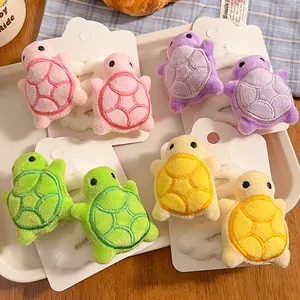 Cute plush turtle hair clips in pink green yellow and purple displayed on a white tray