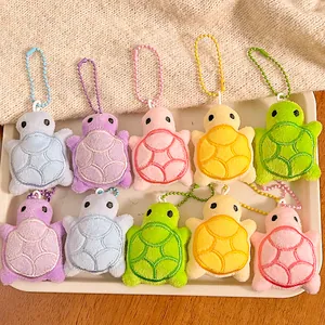 Close-up of colorful plush turtle keychains with detailed shell embroidery and ball chains