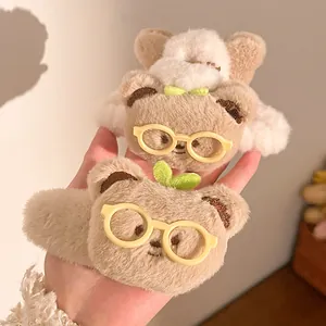 Detailansicht niedlicher Plüschbär-Haarklammern mit gelber Brille und kleinen Blättern