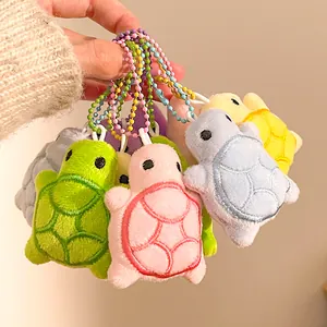 Detail of colorful plush turtle keychains with soft textures and matching bead chains