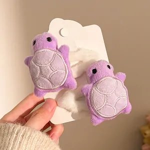 Close-up of cute purple plush turtle hair ties with fine stitching and elastic bands