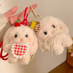 Close-up of plush lop-eared rabbit keychains with cute strawberry and pearl bow details
