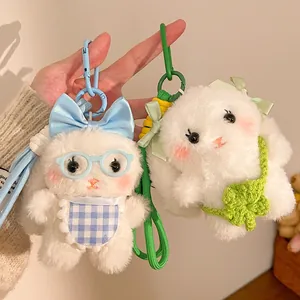 Detail showing two plush lop-eared rabbit keychains with cute bows and knit accessories