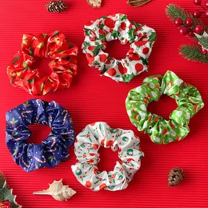 Flat lay of five Christmas satin scrunchies with festive patterns on red background
