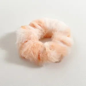Primer plano del coletero de felpa tie-dye melocotón y beige con textura de piel sintética