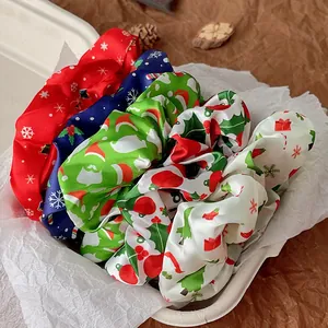Detail view of satin Christmas hair scrunchies with festive patterns in a gift box