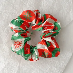 Close-up of a Christmas scrunchie with red and green checkered patterns and snowflakes