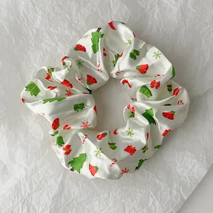 Macro shot of white satin Christmas scrunchie with festive trees and bells print
