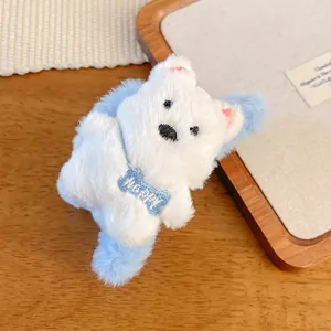 Detail of plush white dog hair clip with blue bone pendant and Happy embroidery
