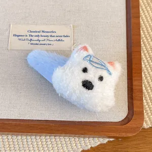 Detail of plush cartoon dog hair clip with blue bow and soft white faux fur texture