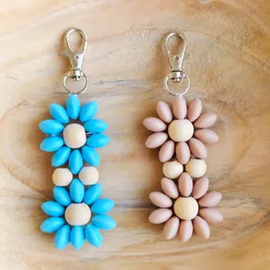 Colorful silicone floral keychains with wooden beads and silver lobster clasps on tray